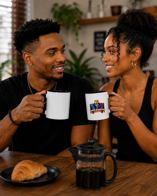 Couple toasting with white Kings & Queens of Dancehall accent mugs over coffee and a croissant.
